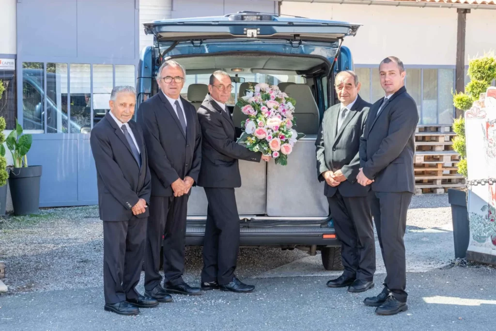 Chauffeurs et porteurs funéraires réunis devant le corbillard d'une agence.