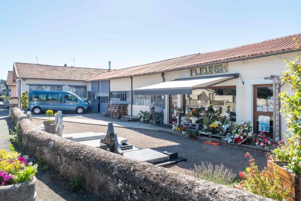 Façade extérieure d'une boutique de fleurs et marbrerie funéraire.