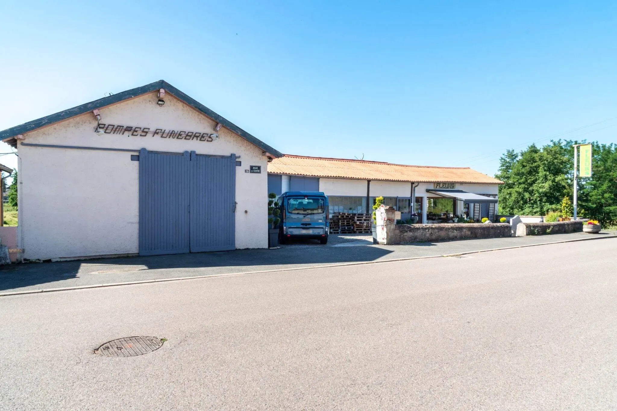 Vue générale des bâtiments et du parking d'une agence de pompes funèbres.